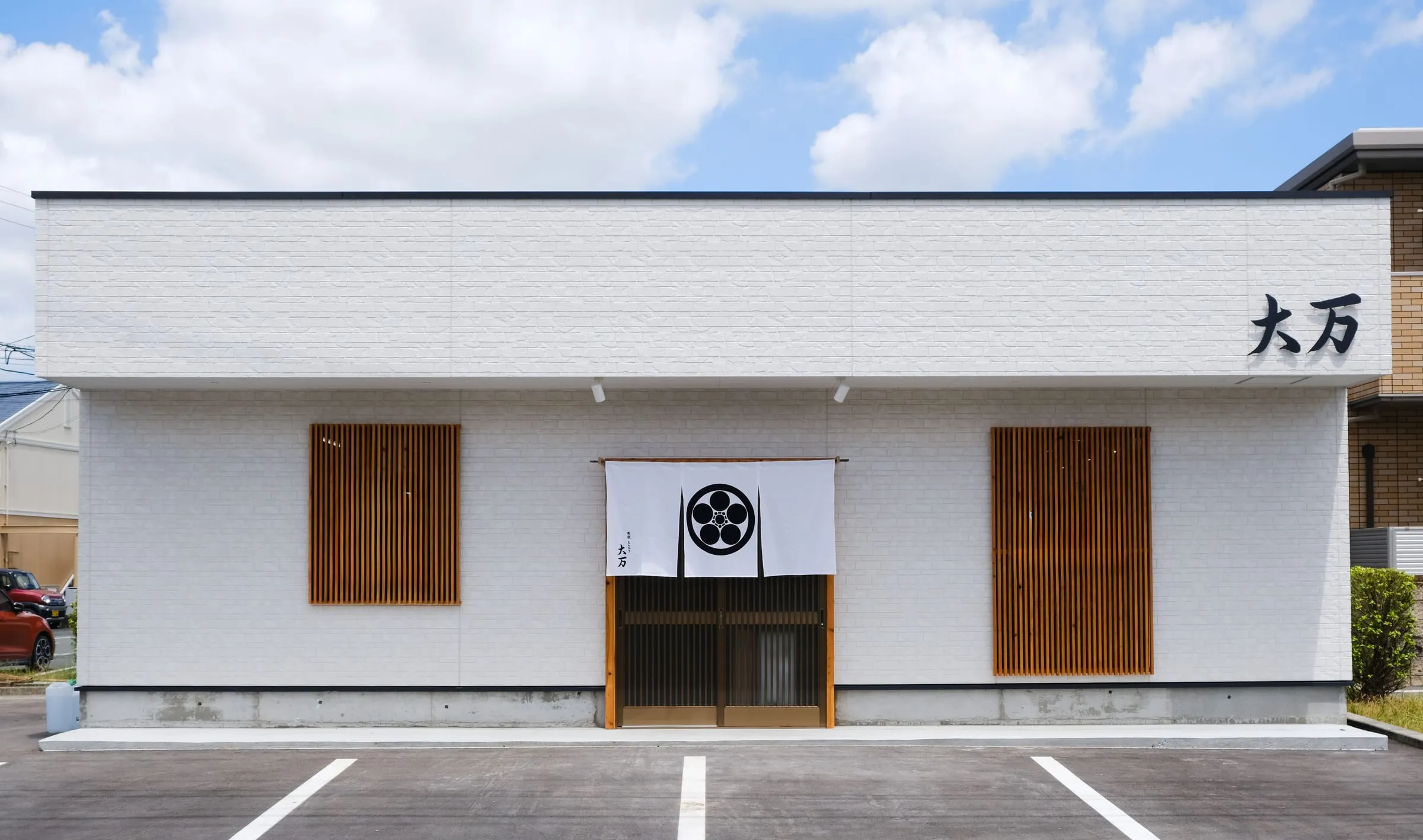 家紋入りの暖簾を掛けた肥後とんかつ 大万の店舗外観